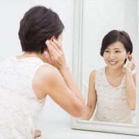 鏡でヘアチェックする女性